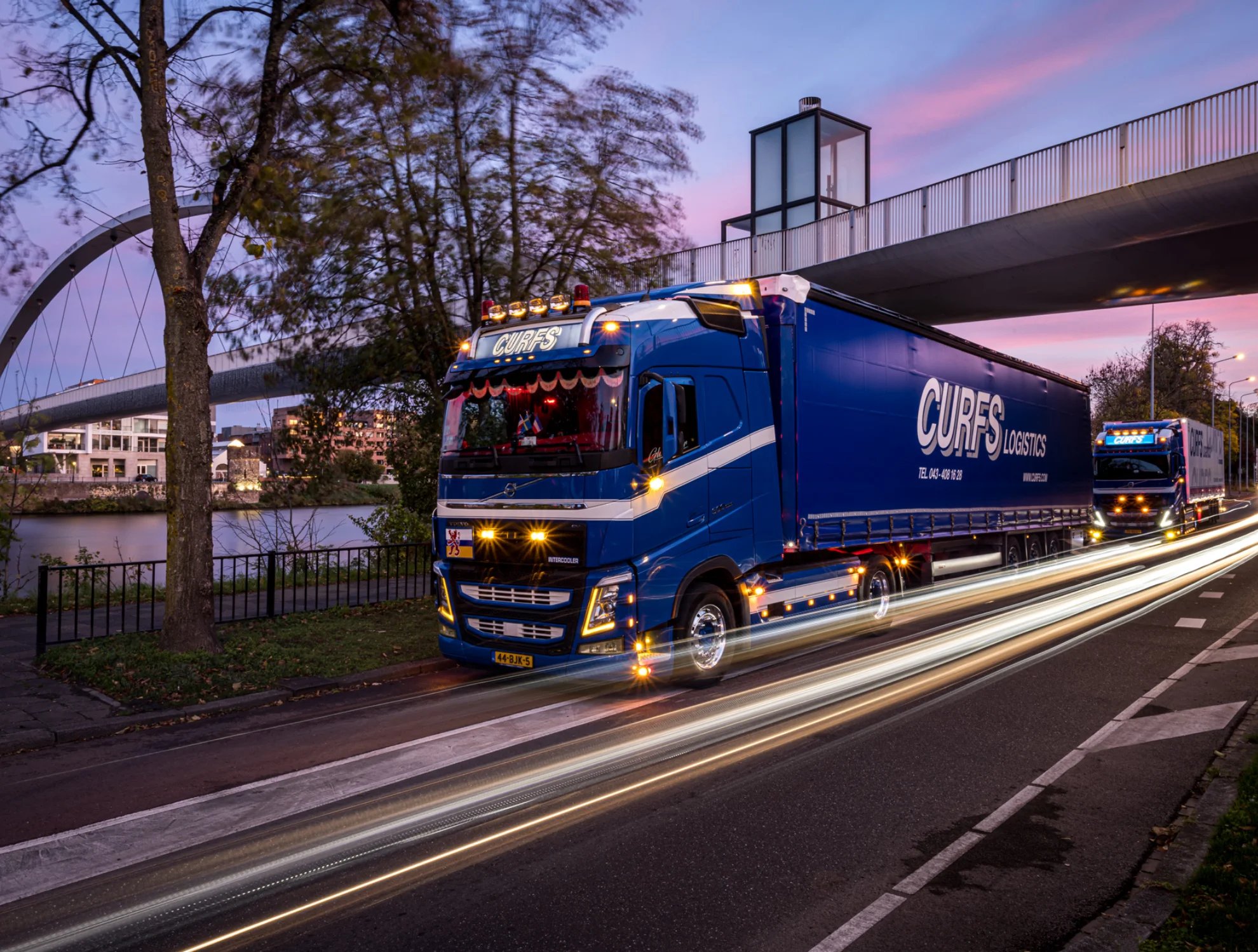 Blauwe vrachtwagen van Curfs Logistics in een stad — symbool voor de non-food logistiek die EVO-IT met transportplanning software optimaliseert.